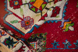Folded corner of a vintage Oushak rug reveals the hand-knotted texture and low pile.