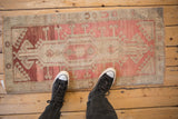 Distressed vintage Oushak rug, faded raspberry and beige medallion with abrashed pile.