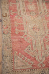 Distressed vintage Oushak rug pile texture, abrashed raspberry red and beige, machine-bound side.