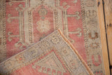 Vintage Distressed Oushak rug: short pile, pale red design, machine bound edge, woven reverse.
