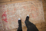 Scale view of the distressed, low-pile texture on a vintage Oushak runner with faded colors.