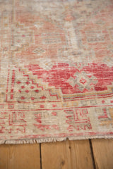 Angled view of the distressed, hand-knotted pile and secured fringe on a vintage Turkish Oushak rug.