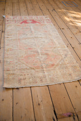 Angled view of a distressed Oushak runner showing its time-softened colors and worn texture.