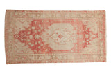 Distressed vintage Oushak runner with a large medallion in soft raspberry red and sand.