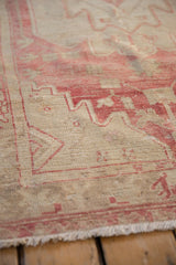 Detail of the distressed weave and raspberry red geometric pattern on a vintage Oushak rug.