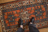 Hand knotted Vintage Karaja rug featuring terracotta, sapphire blue geometric medallion, and vine border.