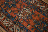 Close-up: Karaja rug's terracotta, sapphire, ivory geometric patterns showing mostly even wear.