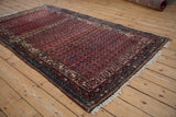 Antique Kurdish Hamadan rug's repeating boteh pattern, dusty rose, sapphire blue, and visible abrashes.