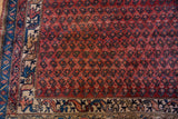 Kurdish Hamadan rug detail: sapphire blue botehs on dusty rose field, geometric border.