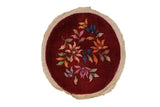 Vintage Art Deco round rug with colorful lotus flowers scattered on a burgundy wine red field.