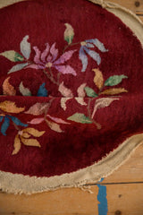 Plush burgundy pile and multi-color floral pattern of a vintage Art Deco rug, shown folded.