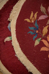 Detail of the vintage rug's burgundy pile, hand-knotted foundation, and side selvage.