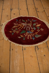 An angled look at the vintage Art Deco round mat's full floral pattern.