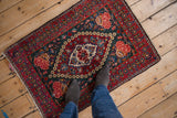 A person's overhead view showing the scale of a vintage Kashan rug's floral medallion.