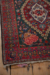 Rose motif corner spandrel and repeating floral border on a vintage Persian Kashan rug.