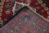 Intact navy side cord selvage and hand-knotted back on a vintage Persian Kashan rug corner.