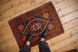 Vintage Persian Kashan rug mat in red and navy, shown in-situ to display scale.