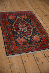 Angled view of a vintage Kashan mat with its concentric medallion and rose motif spandrels.