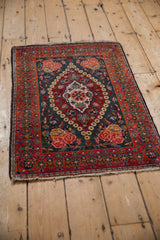 Angled view of a vintage Persian Kashan rug, showing the low pile and traditional floral medallion design.