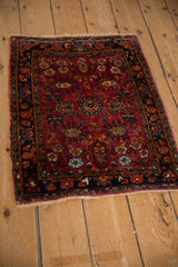 A vintage Lilihan mat showing its contoured shape and dense floral pattern in red and navy.