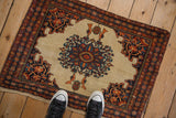 An antique Farahan Sarouk saddle bag rug mat with perched birds and a starburst medallion, viewed from above for scale.