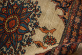 Detailed view of a rare tangerine bird motif on the ivory field of an antique Farahan Sarouk saddle bag.