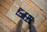 A person stands on a distressed vintage Tulu rug, showing its plush texture and scale.