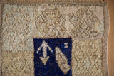 A cobalt blue boteh motif shows the distressed, time-softened texture of a vintage Tulu wool rug.
