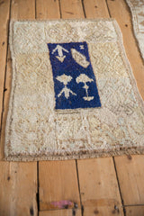 Angled view of a distressed Tulu rug highlighting its shaggy texture and cobalt blue motifs.