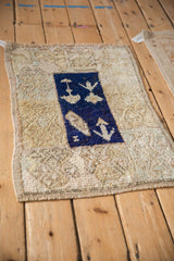 Angled perspective on a distressed Tulu mat, emphasizing its shaggy pile and bold blue geometric panel.