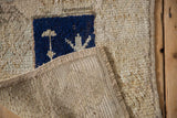 Hand-woven foundation and secured side cord detail of a vintage distressed Tulu rug mat.