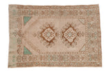 Vintage distressed Oushak rug with a double medallion prayer design in platinum, bronze, and pale turquoise.