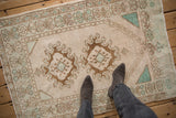 Overhead view of a vintage distressed Oushak rug showing its texture and bronze geometric medallions.