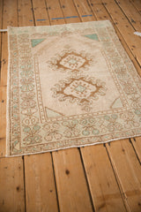 Top corner of a vintage Oushak rug showing the mehrab prayer design and geometric border.