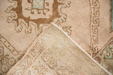Corner view showing the hand-knotted back and distressed low pile of a vintage Turkish Oushak.