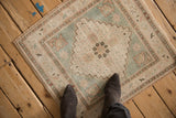 Distressed vintage Oushak rug showcasing soft ivory, seafoam green, and pale rose tones.