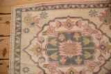 Even wear texture of vintage Oushak rug, showing blue vine border and pink palmette.