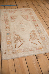 Close-up of Vintage Distressed Oushak rug border with geometric blossoms in sand, teal, and coffee.