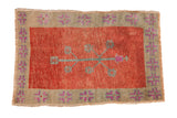 Vintage distressed Oushak rug with a tree of life motif, red field, and sage green geometric border.