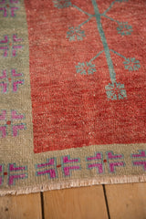 Even wear to knot heads on a distressed Oushak's red field and sage geometric border.
