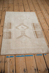 Angled view of a distressed Malatya rug showing its neutral geometric pattern and low-pile texture.