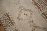 Evenly worn pile on a distressed Malatya rug, detailing its coffee brown hook and latch motif.
