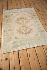 High-angle view of a vintage distressed Oushak rug's soft palette and evenly worn, low pile.