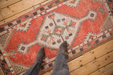 Distressed Oushak runner texture with brick red and ivory hues, showing even wear.