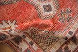 Distressed brick red pile with charcoal stepped medallion and ivory floral guls on a vintage Oushak rug.