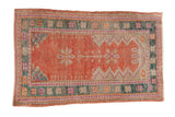 Distressed Oushak rug with a melon prayer design, zig-zag mehrab, and a dusty teal geometric border.