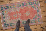Softly worn vintage Oushak rug with a cantaloupe prayer design and a dusty teal border.