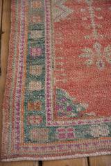Intact side cord selvage and teal geometric border on a hand-knotted vintage Oushak rug.