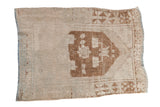 Vintage distressed Oushak rug with a hexagonal brown medallion on an ivory field with heavy abrashes.