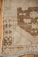 Low pile texture and primitive geometric border of a distressed vintage Turkish Oushak rug.